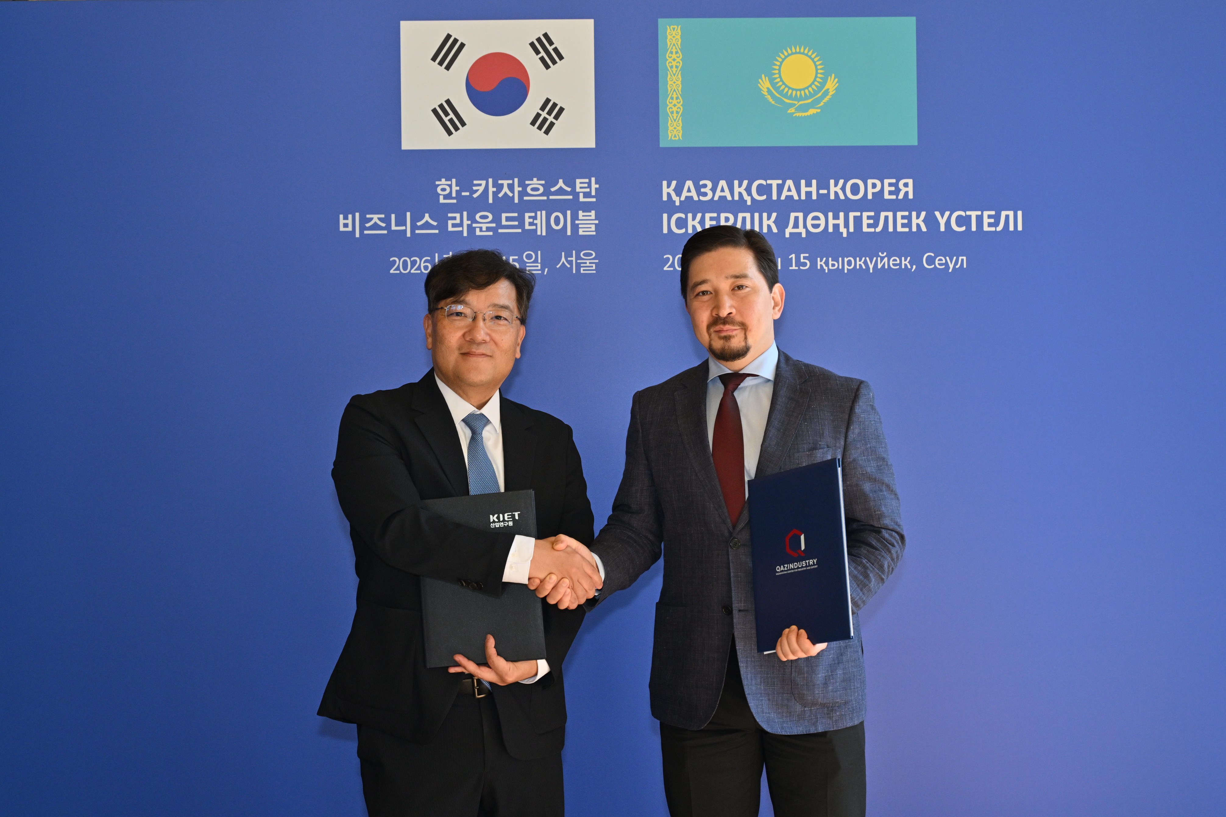The heads of KIET and QazIndustry shaking hands